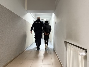 Policjant prowadzi zatrzymanego