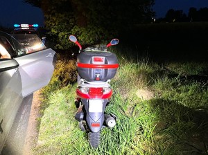 Motorower, w tle radiowóz